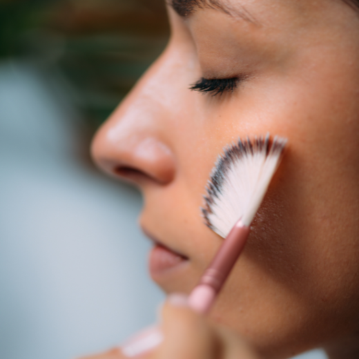 Woman Applying At Home Skin Care To Face with Brush